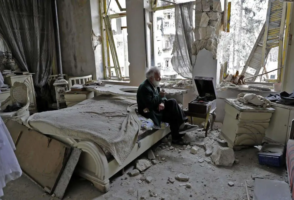 L'anziano, la pipa e il grammofono tra le macerie: la foto simbolo della guerra in Siria